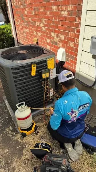 Technician servicing an outdoor condenser with refrigerant gauges