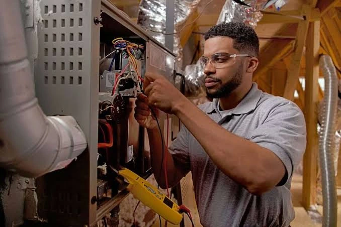 Technician checking wiring in a heating system