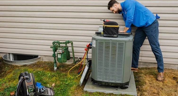 HVAC technician servicing an outdoor residential air conditioning unit